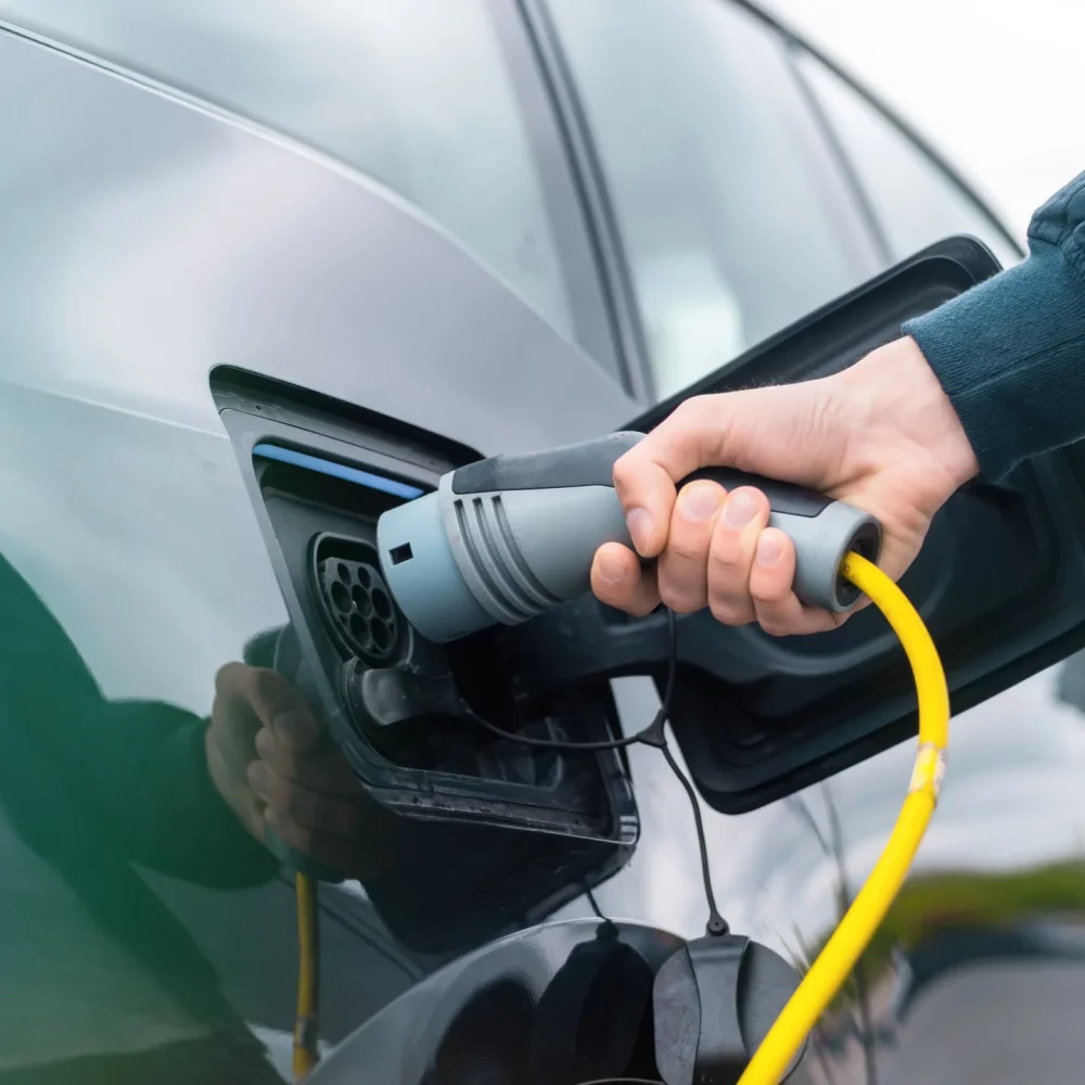 homme-branchant-chargeur-dans-voiture-electrique-station-charge-min