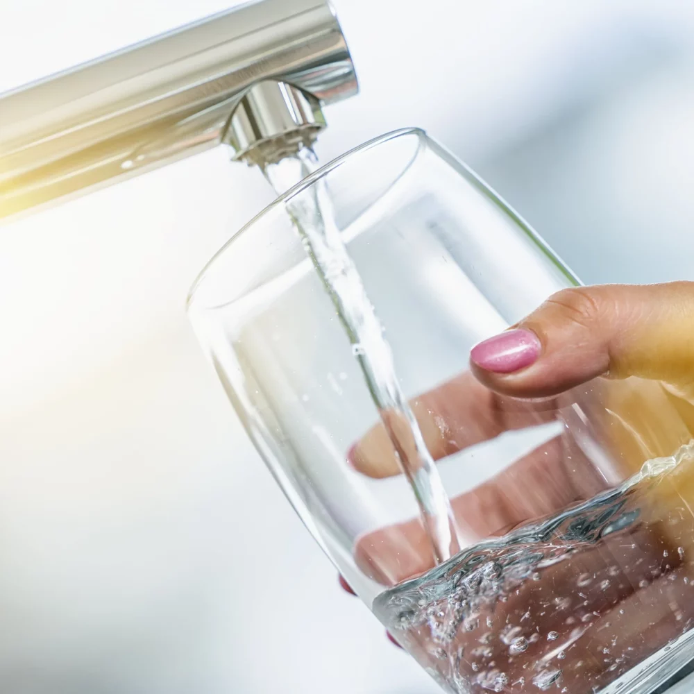main-femme-remplit-verre-eau-min main-femme-remplit-verre-eau-min